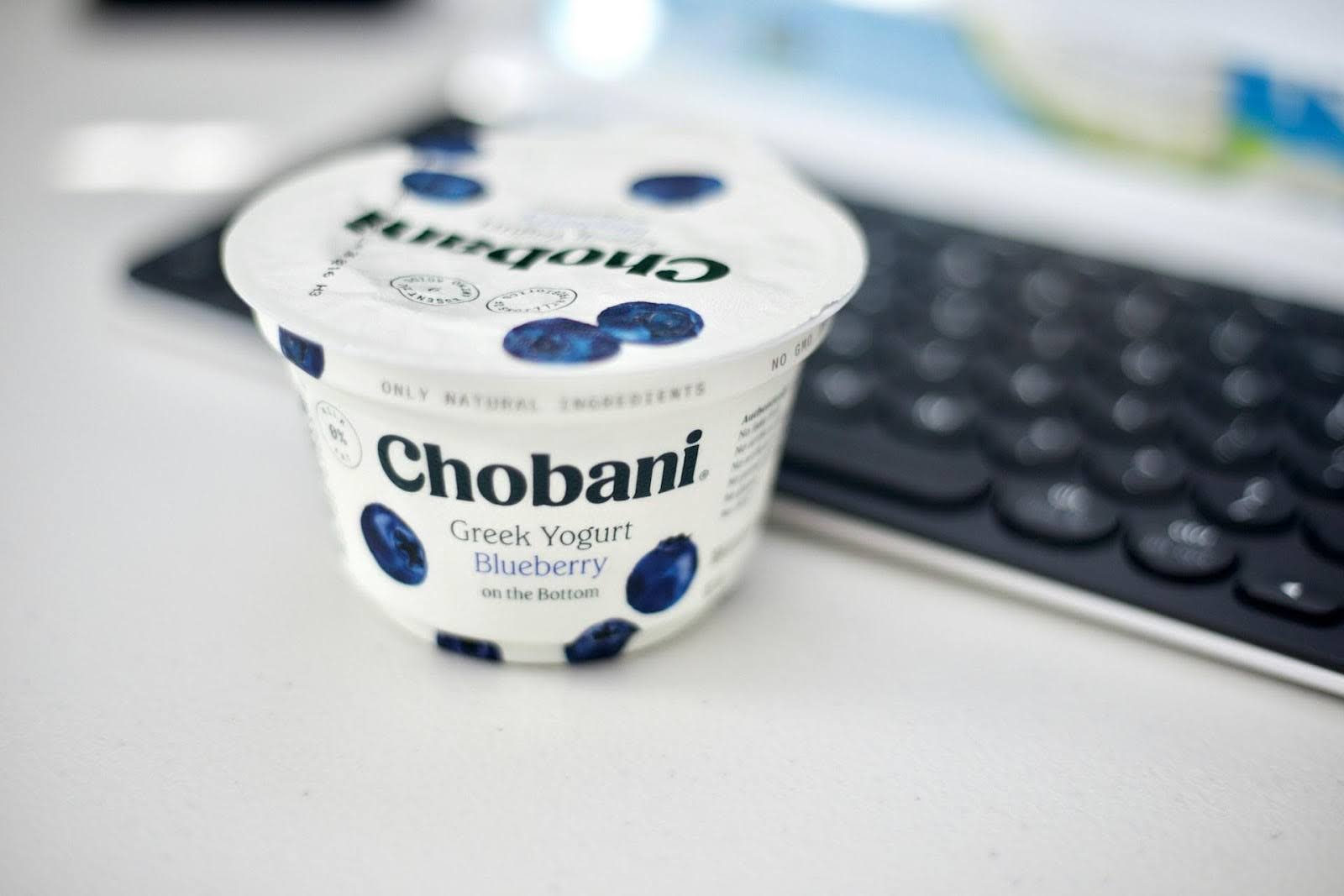 Greek yogurt next to a PC keyboard.
