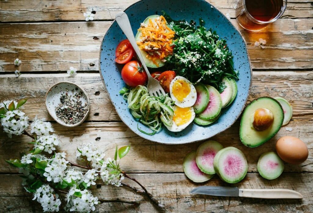 A plate full of food next to some avocados.