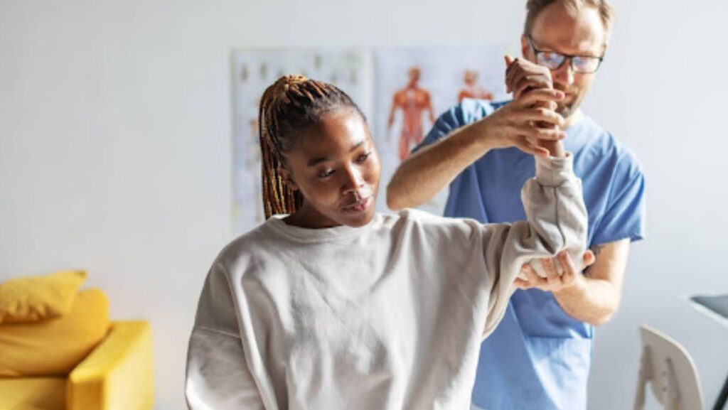 Therapist assists patient with arm mobility exercises, focusing on restoring function for a safe return to sport.